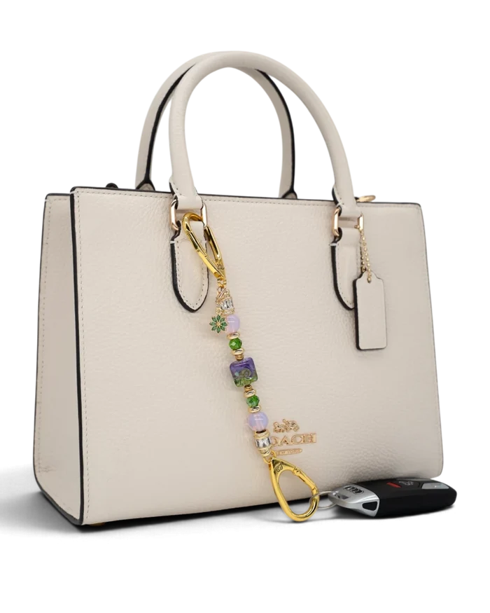 LD Keyfinder Petite Verdant Bloom accessory featuring lampwork glass, pink opalite, and gold-plated flower charm on bag