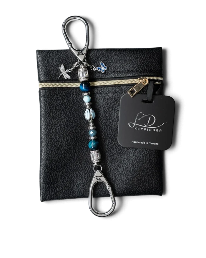 LD Keyfinder Petite Whispering Garden keychain with blue tiger eye, glass tulip, and dragonfly charm on a black pouch.