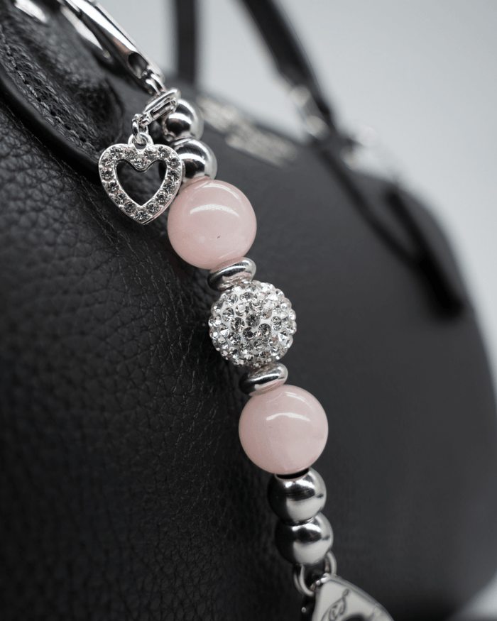 LD Keyfinder Princess Pink Mini keychain with rose quartz beads, rhinestone spacers, and a heart charm on a handbag.