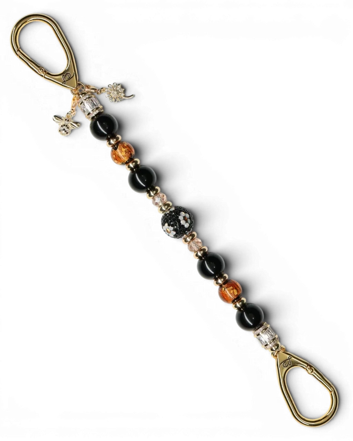 LD Keyfinder Queen Bee II keychain with black obsidian, amber, and gold beads, crystal daisy center, and bumblebee charm.