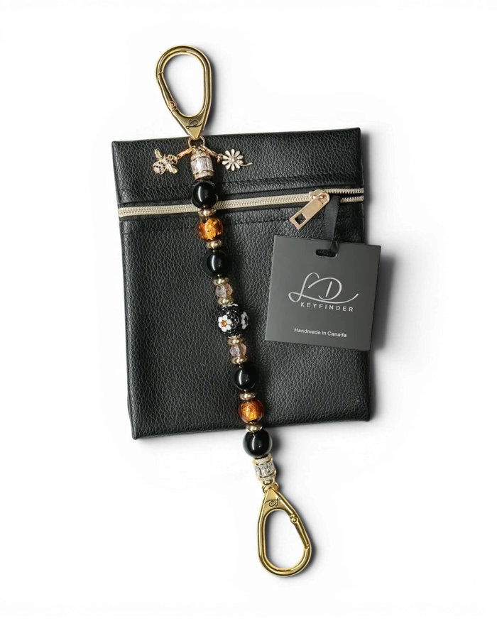 LD Keyfinder Queen Bee II keychain with black obsidian, gold, and crystal beads, featuring a bee charm and daisy charm.
