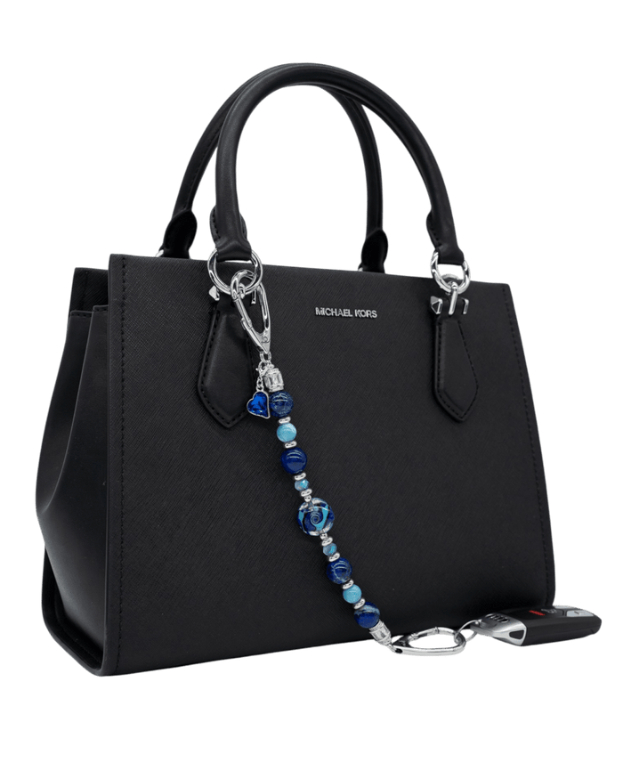 LD Keyfinder Sapphire Allure beaded accessory with blue jasper, larimar, and glass beads attached to a black handbag.