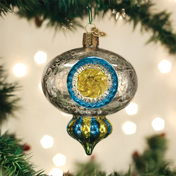Decorative Christmas ornament with blue and gold design on a tree with lights in the background