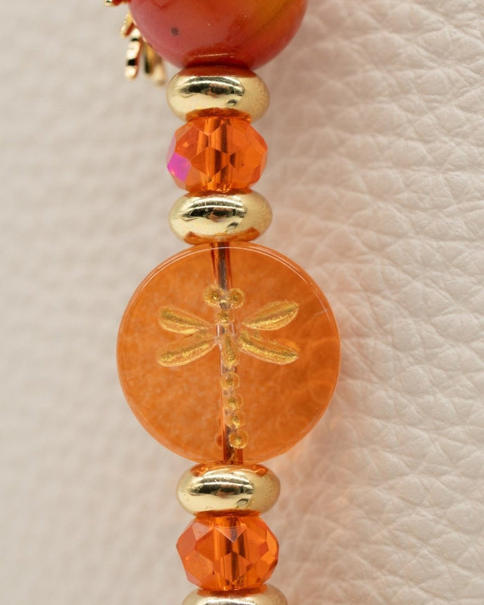 Electroplated coral glass center bead with metal-enlaced hand-painted dragonfly