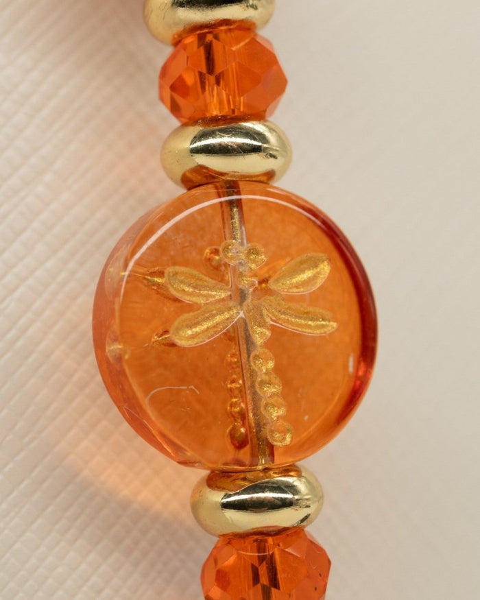 Electroplated coral glass center bead with metal-enlaced hand-painted dragonfly