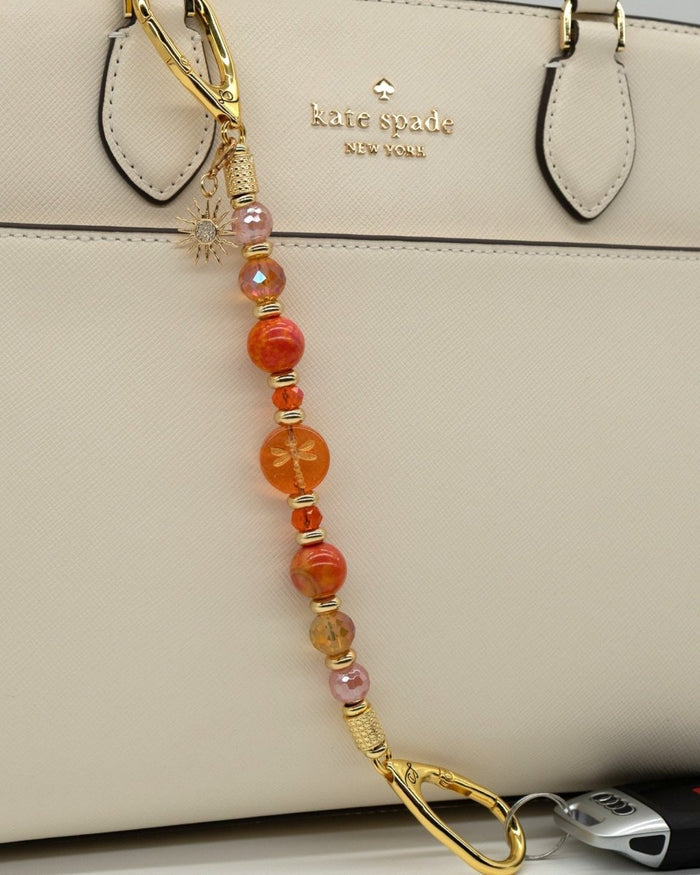 LD Keyfinder Summer Sunset beaded accessory with cherry quartz, agate, glass beads, and gold-plated sun charm on a bag