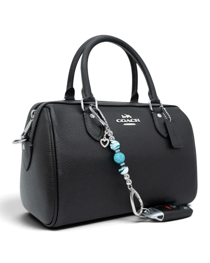 LD Keyfinder Teal My Heart-Mini charm with teal swirl glass beads and a silver heart attached to a black leather bag.