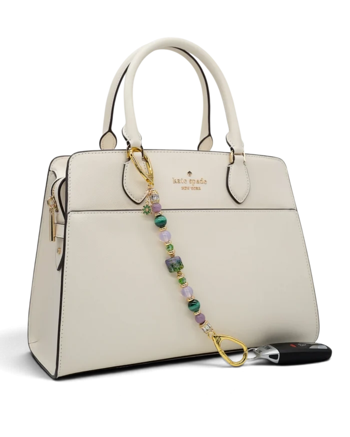 LD Keyfinder Verdant Bloom beaded keychain with malachite, opalite, and lampwork glass attached to a white handbag