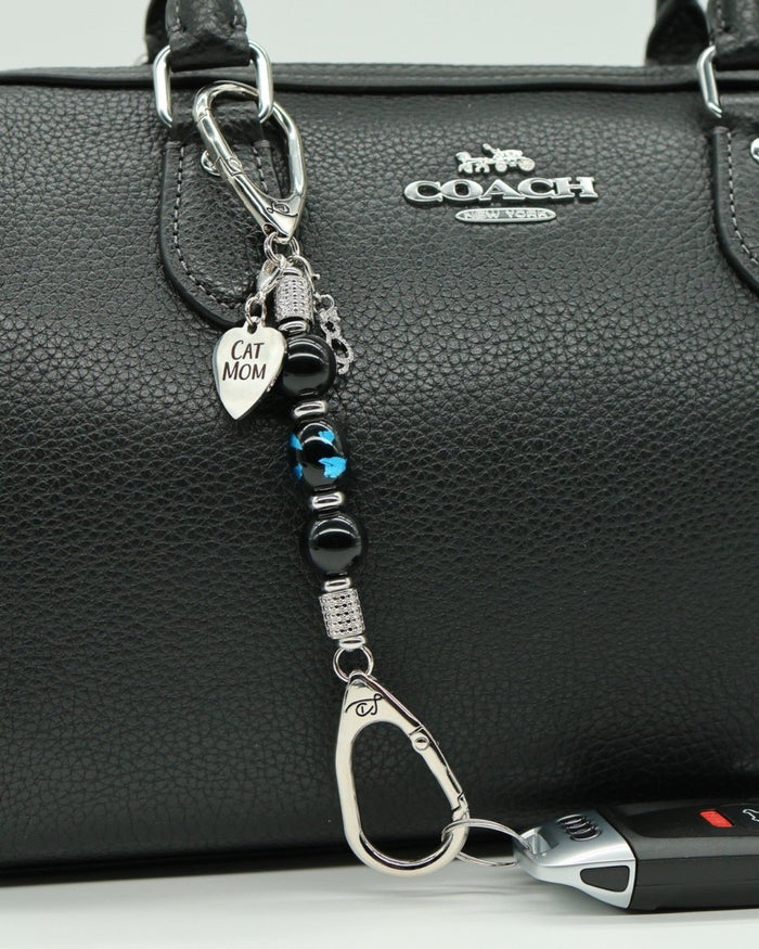 LD Keyfinder Whisker Dreams-Mini featuring black obsidian beads, blue foil cat glass, and Cat Mom charm on a handbag