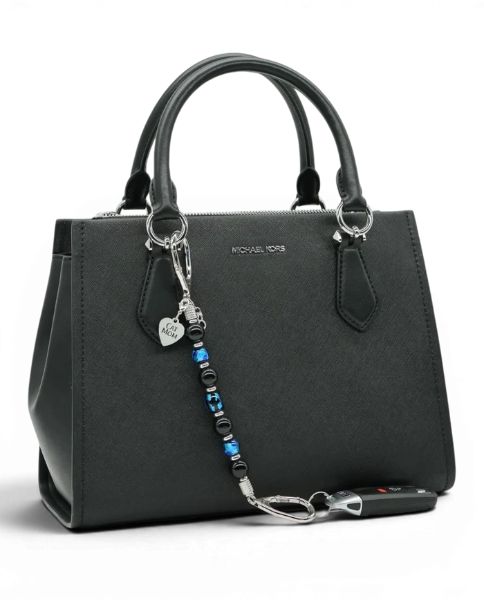 LD Keyfinder Whisker Dreams beaded keychain with black obsidian and blue foil glass beads attached to a black handbag.